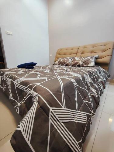 a bed with a brown and white comforter and pillows at JPP Austin市区 3马力中央冷气 自动麻将机 游戏机 6分钟到 tebrau aeon toppen lotus in Johor Bahru