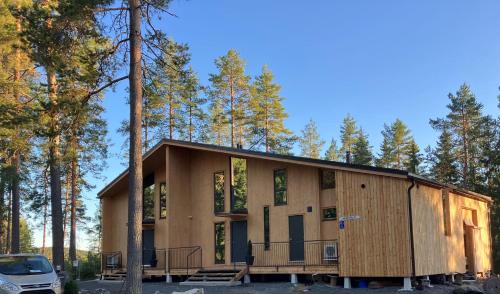 a house in the woods with a car parked in front at Havu Resort Laajavuori, a calm and peasefull place in the forest near city in Jyväskylä