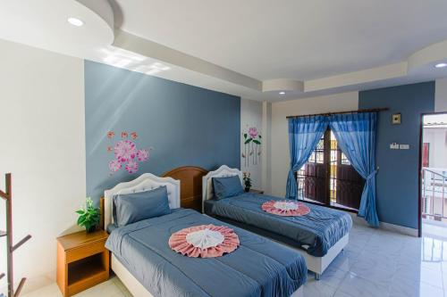 パトンビーチにあるPailin Hill Hotelの青い壁のドミトリールーム ベッド2台