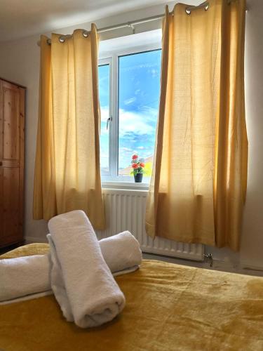a bedroom with a bed with yellow curtains and a window at Langdale House 5 bedroom 7 beds 3 bathrooms in Derby