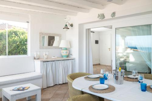 Una sala de estar con una mesa y sillas blancas. en S'Abba seafront apartments - Your House in Sardinia, en Golfo Aranci