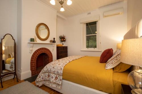 una camera con letto, camino e specchio di The Retreat in Basket Range a Basket Range