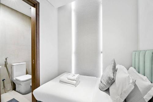 um quarto branco com uma cama e um espelho em StoneTree - Anwa By Omniyat 2BR - Luxury Apartment em Dubai