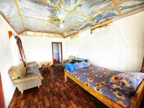 um quarto com um tecto com uma cama e uma cadeira em Nature's Nest Cottage 