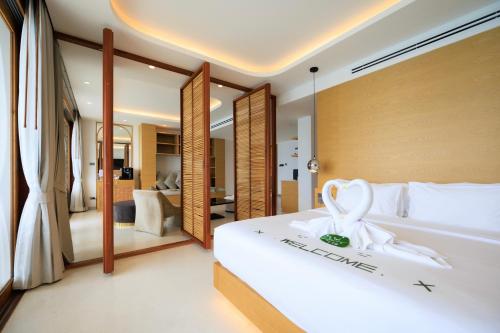 um quarto com uma grande cama branca num quarto em Luxury Penthouse - Khanom em Ban Plau