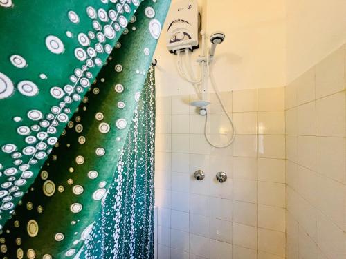 a shower with a green and white shower curtain at Casa Hera Diani in Diani Beach