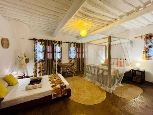 a bedroom with a bed and a table in it at Casa Hera in Diani Beach