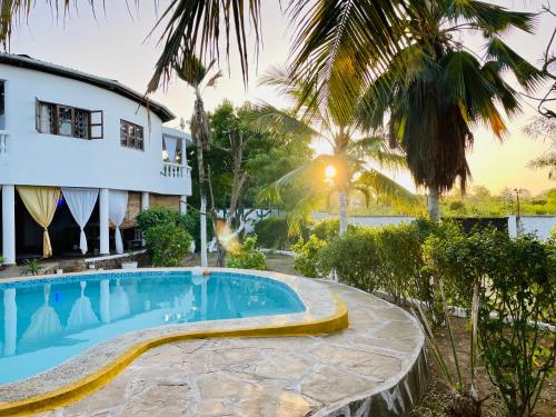 una villa con piscina di fronte a una casa di Casa Hera a Diani Beach