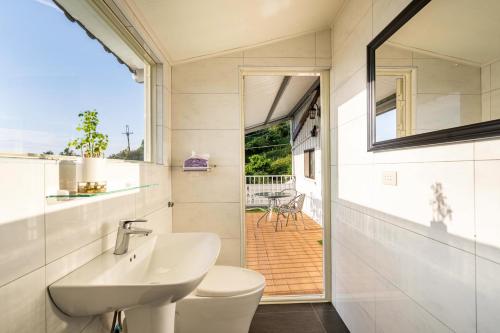 a bathroom with a sink and a toilet and a window at 歐森View包棟Villa x 雲海夜景 x 獨立空間 in Dongshi