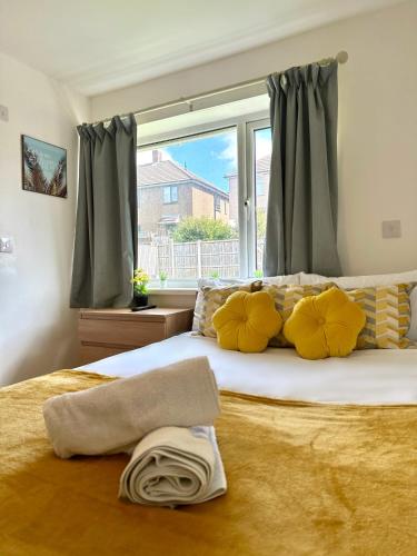 a bedroom with a bed with yellow pillows and a window at Langdale House 5 bedroom 7 beds 3 bathrooms in Derby