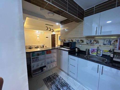 a kitchen with white cabinets and a sink at Apartment Hossam 1 in Hurghada