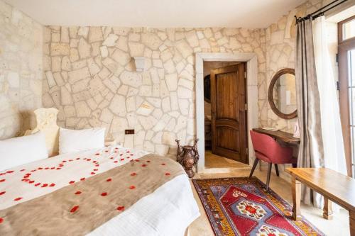 a bedroom with a bed and a stone wall at Castle Panorama House in Nevsehir
