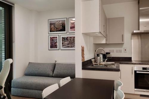 uma cozinha e uma sala de estar com uma mesa e um sofá em Beautiful modern flat with 1 bedroom near Old Street Station em Londres