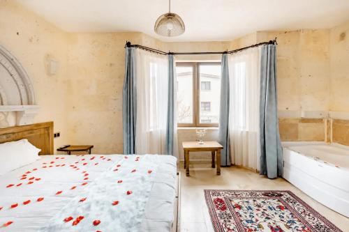 a bedroom with a bed and a bath tub next to a window at Castle Panorama House in Nevsehir