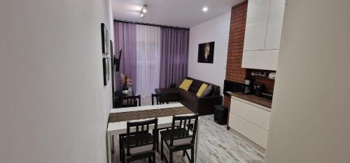 a kitchen and living room with a table and chairs at Apartament Leopard in Bydgoszcz