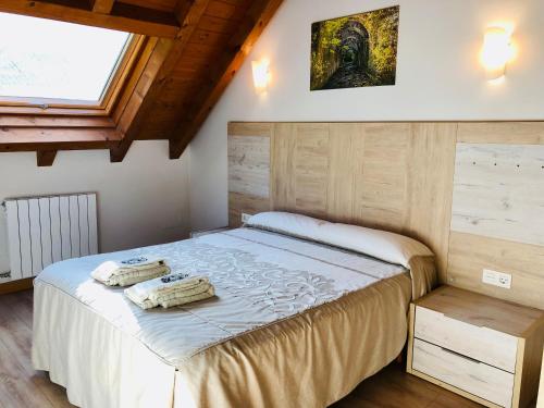 a bedroom with a bed with two towels on it at Apartamentos Zabalarena Basoa in Orbaiceta