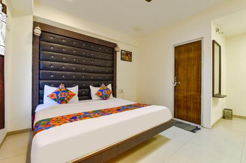 a bedroom with a large bed with a large headboard at FabHotel Crystal Inn II in Ahmedabad