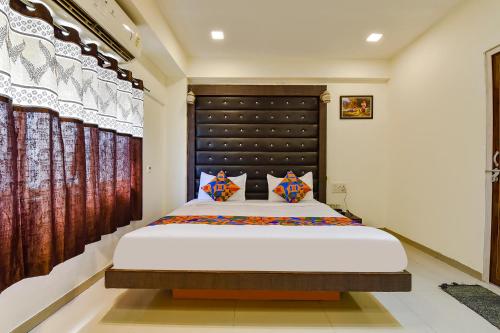 sypialnia z dużym łóżkiem w pokoju w obiekcie FabHotel Crystal Inn II w mieście Ahmadabad