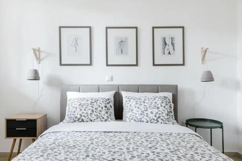 - une chambre dotée d'un lit avec 3 photos sur le mur dans l'établissement Ένα διαμέρισμα με χαρακτήρα, à Athènes