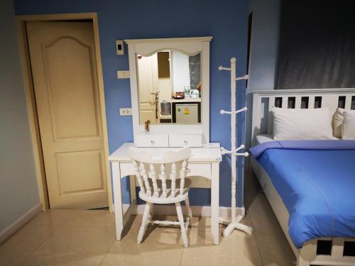 a bedroom with a desk and a bed with a mirror at Baanchomchan in Hua Hin