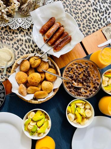 a table topped with plates of food and fruit at Casa Hera Diani in Diani Beach
