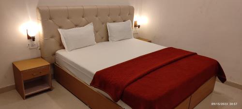 ein Schlafzimmer mit einem großen Bett mit einer roten Decke in der Unterkunft Khajurāho Hostel in Khajurāho
