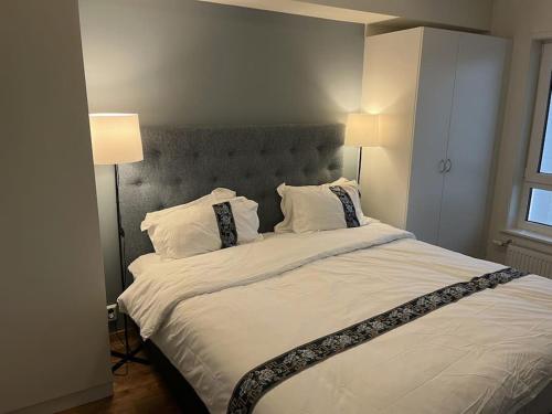 a bedroom with a large white bed with two lamps at Scandpoint Apartment Lillestrom -Cosy 3 rooms flat with free Parking, EV Charger 18 min from Airport in Lillestrøm