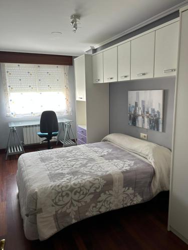 - une chambre avec un lit, une chaise et une fenêtre dans l'établissement Piso de Ana, à Narón