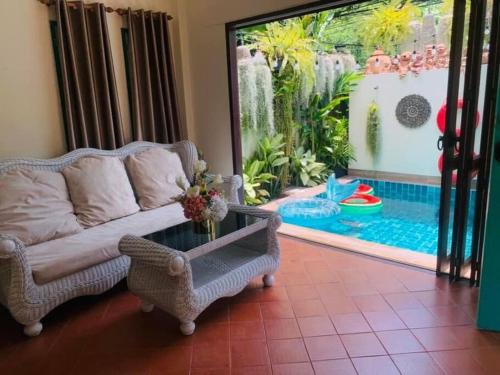 a living room with a couch and a pool at The Rain tree, Pool villa Pattaya in Pattaya Central