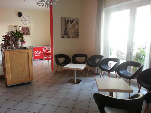 a waiting room with chairs and tables in a restaurant at Hotel La Parigina in Cesenatico