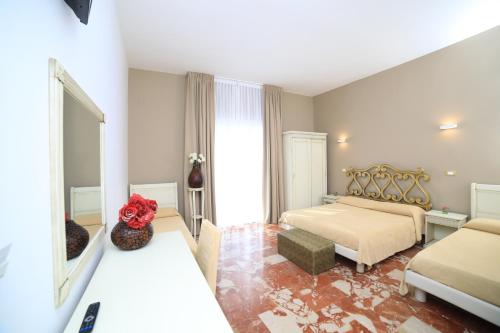 een slaapkamer met 2 bedden en een spiegel bij Quilungomare in Porto Cesareo