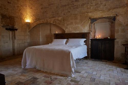 a bedroom with a large bed in a stone room at Sextantio Le Grotte Della Civita in Matera