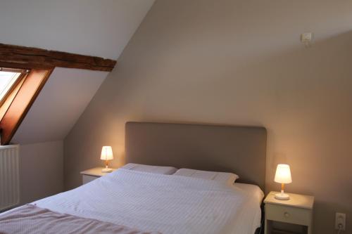 a bedroom with a white bed and two lamps at Le Grenier de la Floye - Gîte Coquelicot in Mettet