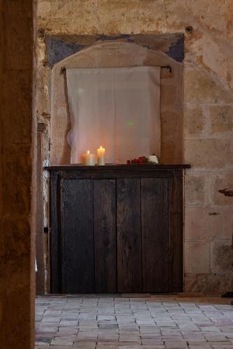 a wooden altar with candles in a stone wall at Sextantio Le Grotte Della Civita in Matera