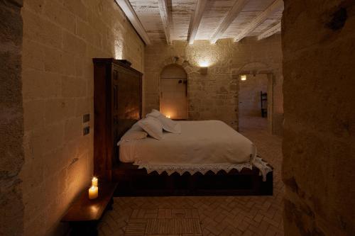 a bedroom with a bed in a stone room at Sextantio Le Grotte Della Civita in Matera