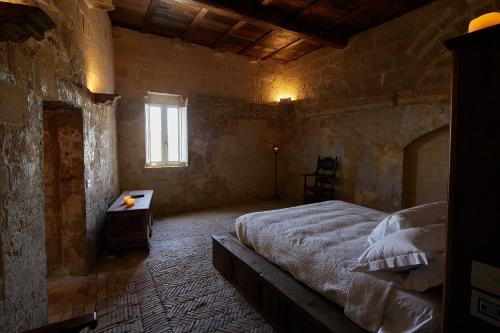 a bedroom with a large bed and a window at Sextantio Le Grotte Della Civita in Matera