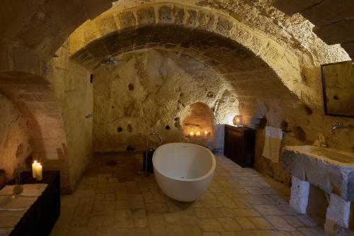 a bathroom with a bath tub in a stone wall at Sextantio Le Grotte Della Civita in Matera
