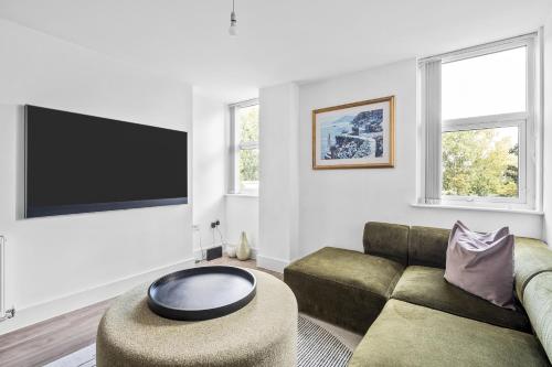 a living room with a couch and a tv at Luxurious 2 Bedroom Apartment with Free Parking in Chelmsford