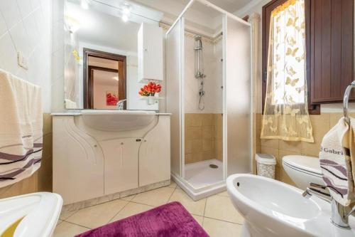 y baño con lavabo, aseo y ducha. en Appartamento Platino, en Marongiu