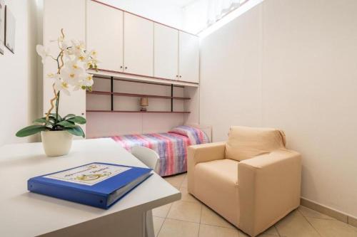 una habitación con una silla y una mesa con un libro en Appartamento Platino, en Marongiu