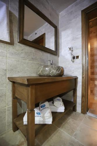 a bathroom with a sink and a mirror and towels at Castle Panorama House in Nevsehir