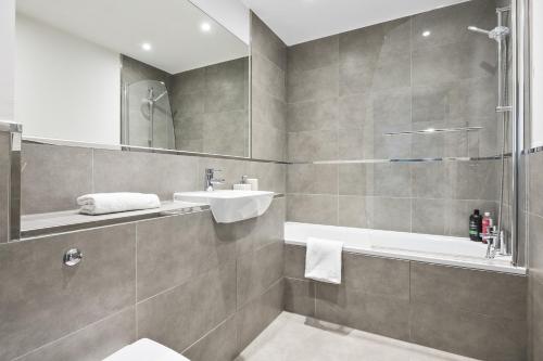 a bathroom with a sink and a toilet and a tub at Luxurious 2 Bedroom Apartment with Free Parking, Sky TV, Sports, Movies & Netflix in Chelmsford
