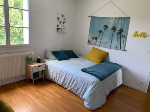 Schlafzimmer mit einem Bett mit blauen und gelben Kissen in der Unterkunft JO 2024 Maison avec jardin proche Paris Versailles in Saclay