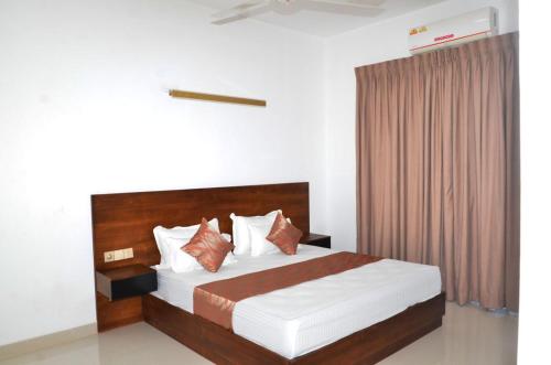 a bedroom with a large bed with a wooden headboard at SkyGate Residences in Nugegoda