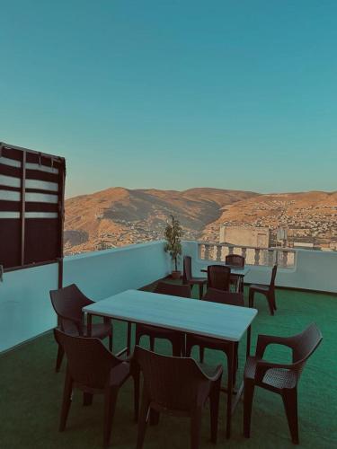 a group of tables and chairs on a balcony at Leen Guest House in Wadi Musa