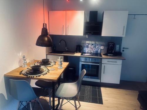 a kitchen with a table and chairs and a kitchen with white cabinets at Whg 4 Ferienwohnung Wuppertal Ronsdorf mitten im Bergischen Land in Wuppertal