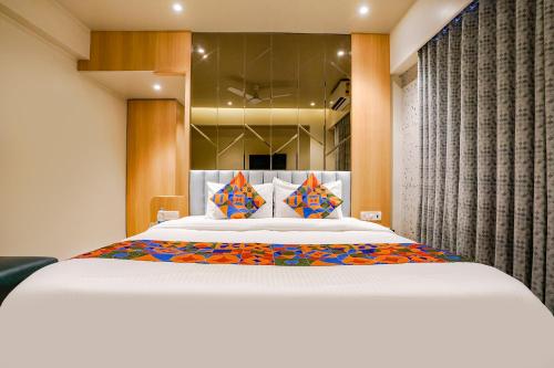 ein Schlafzimmer mit einem großen weißen Bett mit bunten Kissen in der Unterkunft FabHotel Springs Lodging in Mire