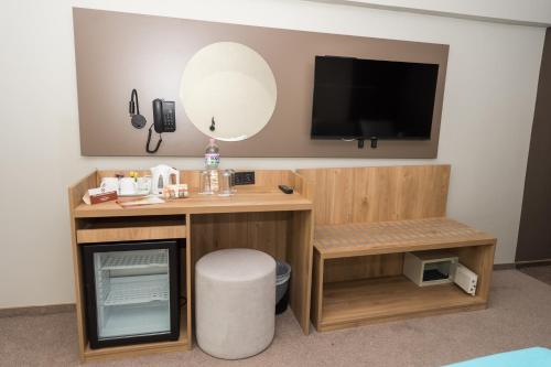 um quarto com uma secretária, uma televisão e um espelho em Grand Hotel Sunny Beach - All Inclusive em Sunny Beach
