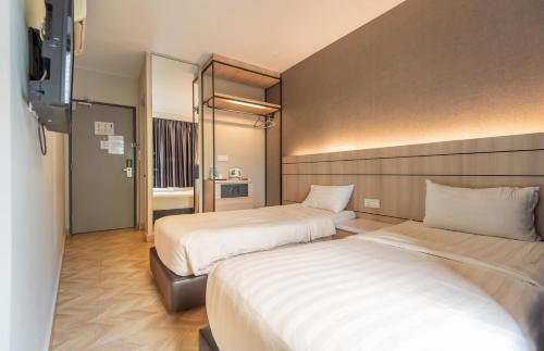een hotelkamer met 2 bedden en een televisie bij Bpod at Setapak KL in Kuala Lumpur