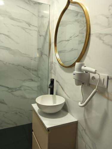 a bathroom with a sink and a mirror at Apartamentos Luis in Arzúa